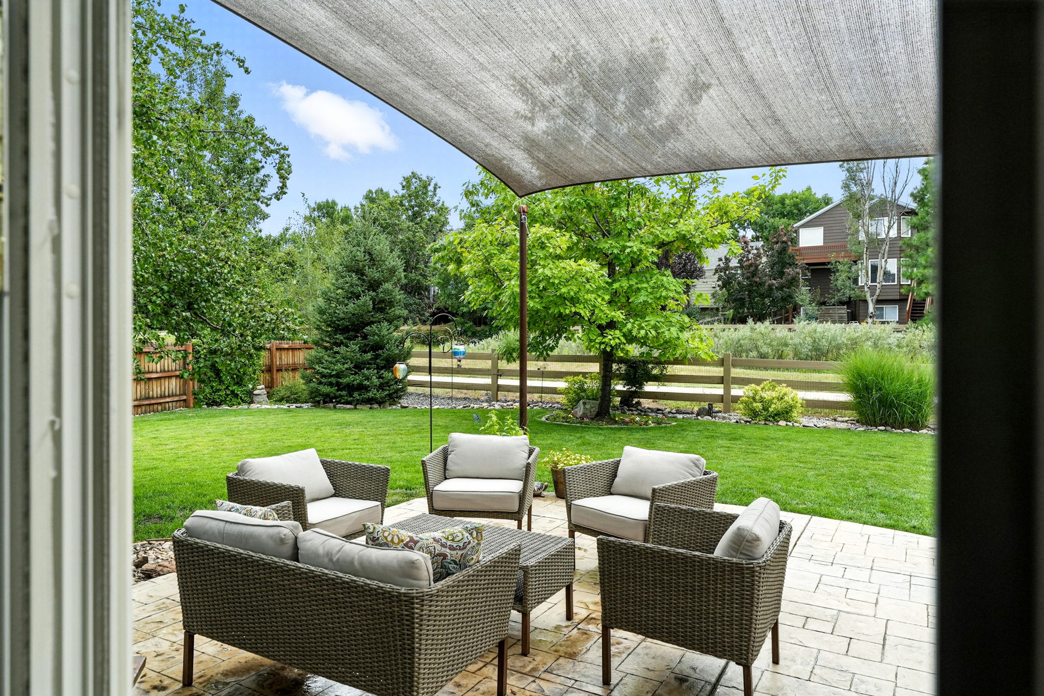 covered patio seating area overlooking backyard and greenbelt Erie home