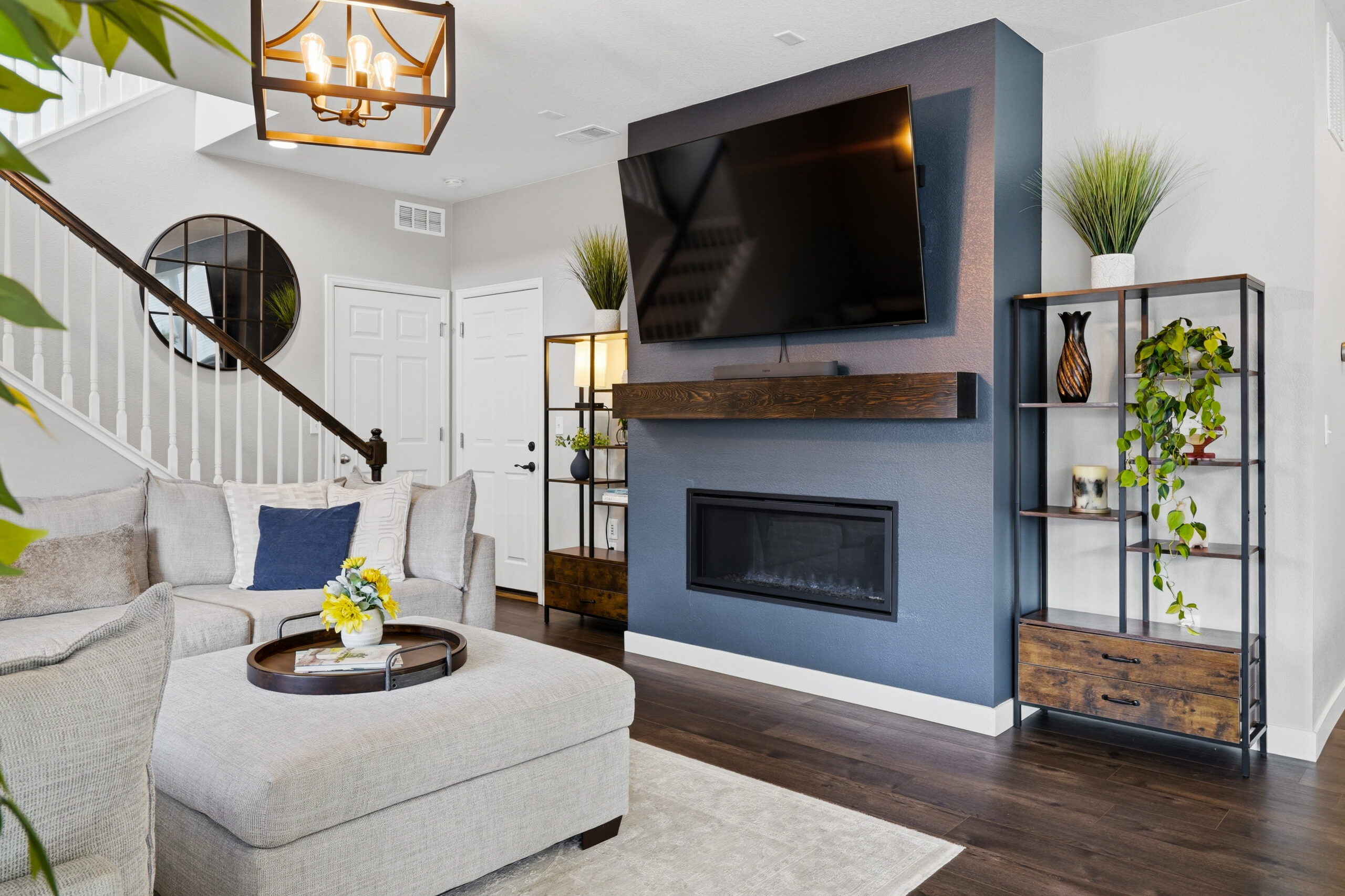 Bright living room with fireplace, mounted TV, and open staircase at 762 Eva Peak Dr in Erie Colorado
