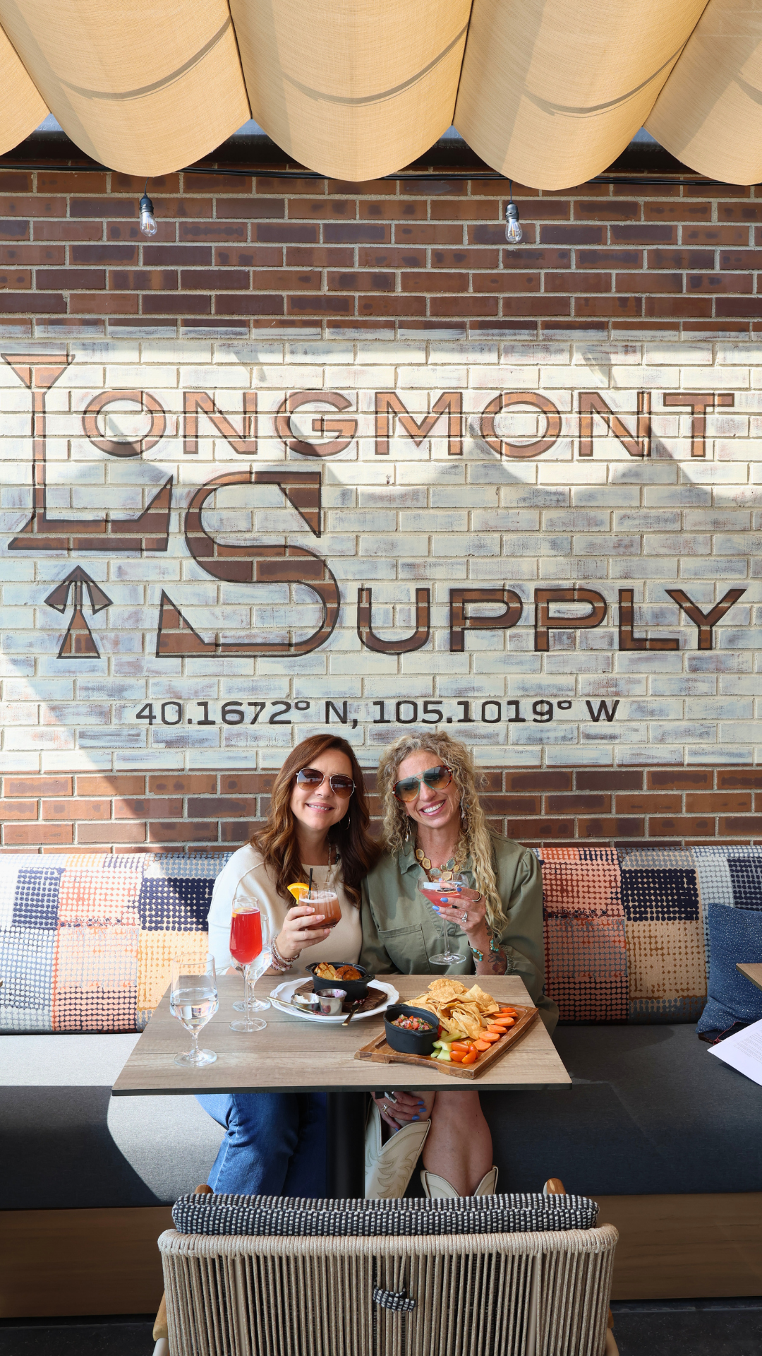 Jessica and Misti enjoying cocktails and appetizers at Longmont Supply, a rooftop restaurant in downtown Longmont, Colorado.